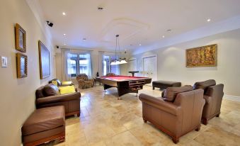 a large living room with multiple couches and chairs arranged around a pool table , creating a comfortable space for socializing at Château Venise