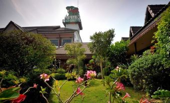 a beautiful garden with a variety of flowers , including pink and white roses , in front of a building at Mammoth Resort