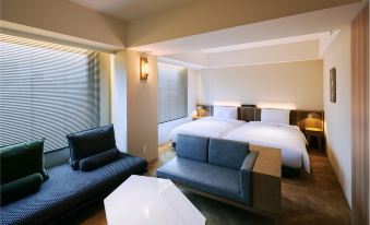a modern hotel room with a large window , white walls , and blue furniture , including a bed , couch , and nightstands at Nohga Hotel Akihabara Tokyo