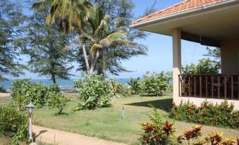 a tropical resort with palm trees , lush greenery , and a view of the ocean in the background at Ao Thai Resort