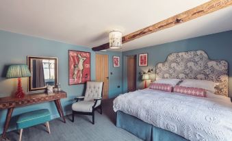 a cozy bedroom with a blue and white color scheme , featuring a large bed , a dresser , and a chair at The New Inn - Yealand