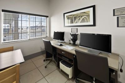 a room with two computer desks , each equipped with a computer monitor and keyboard , as well as a printer at Country Inn & Suites by Radisson, Watertown, SD