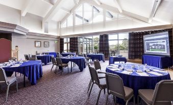 a large conference room with multiple tables and chairs arranged for a meeting or event at Castle Green Hotel in Kendal, BW Premier Collection