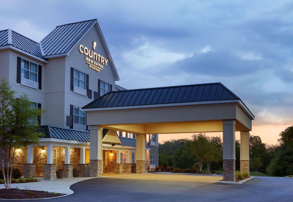 "a large building with the words "" country inn & suites "" on it , surrounded by trees and other buildings" at Country Inn & Suites by Radisson, Ashland - Hanover, VA
