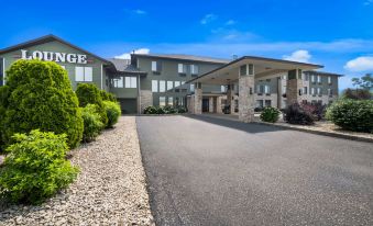 "a large building with a sign that says "" manager "" is surrounded by greenery and rocks" at Best Western Park Oasis Inn