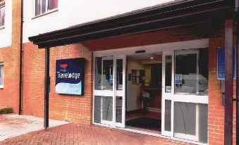 "a brick building with a sign that reads "" travelodge "" prominently displayed on the front door" at Travelodge Porthmadog