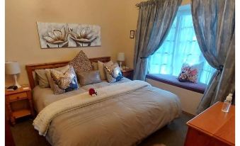 a cozy bedroom with a large bed and a window , creating a warm and inviting atmosphere at Little Milton