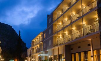 a large hotel building with many windows and balconies lit up at night , creating a beautiful nighttime atmosphere at Park Hotel