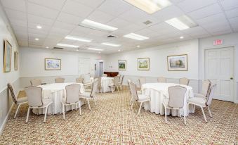 a large dining room with tables and chairs arranged for a group of people to enjoy a meal together at The Farmington Inn and Suites