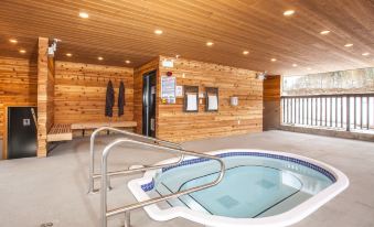 a hot tub is located in a room with wooden walls and benches , surrounded by a metal railing at Boulder Mountain Resort