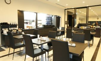 a dining room with tables and chairs arranged for a group of people to enjoy a meal together at Dormy Inn Mishima