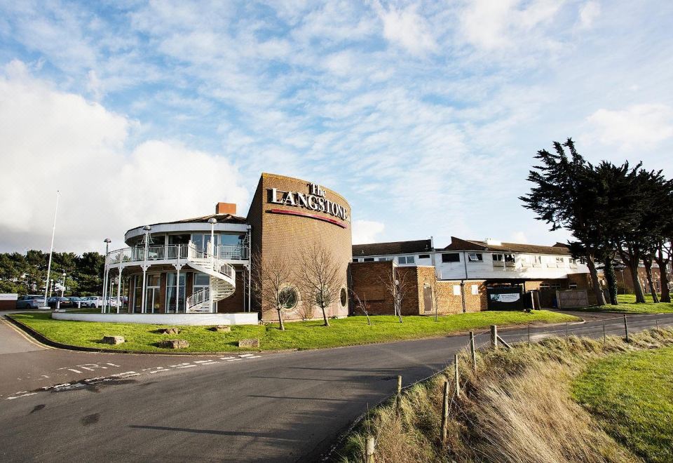 "a large building with a sign that says "" lannswell "" is surrounded by grass and trees" at Langstone Quays Resort