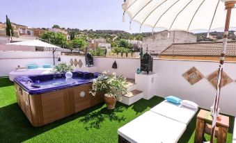 a rooftop patio with a hot tub and a lounge chair , surrounded by green grass at La Esperanza