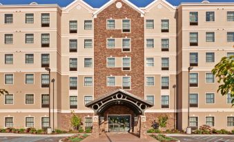 "a large hotel with a brown and white exterior , featuring multiple windows and a sign that reads "" new york new york .""." at Staybridge Suites Buffalo