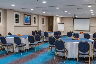 a conference room set up for a meeting , with tables and chairs arranged in rows at Wyndham Reef Resort Grand Cayman