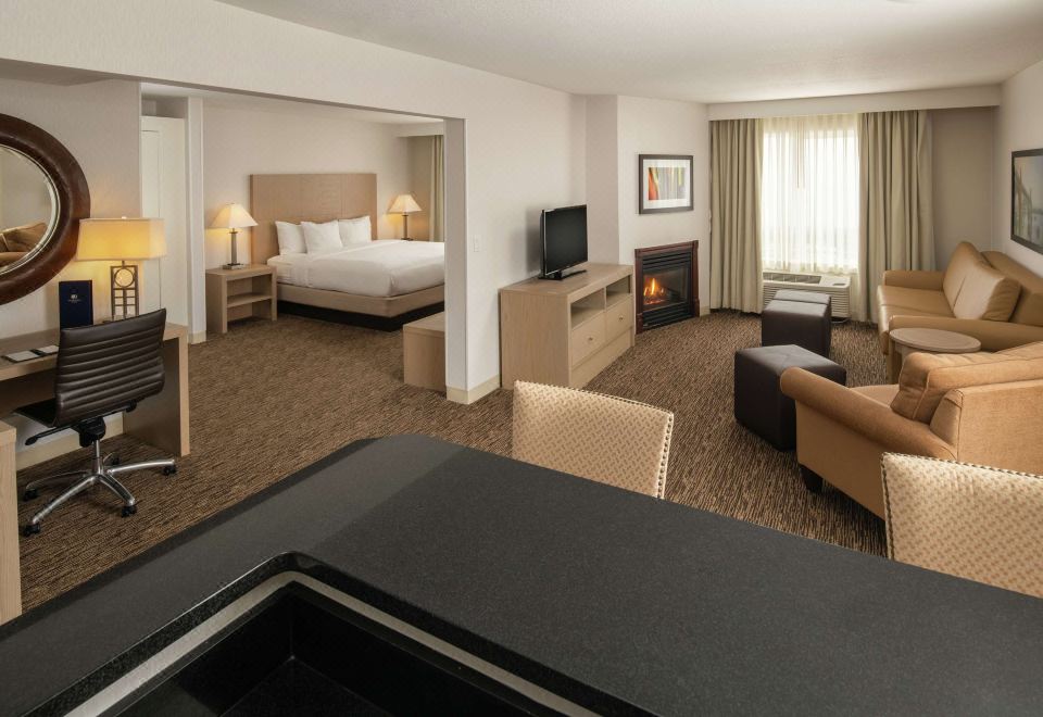 a hotel room with a king - sized bed , a flat - screen tv , a desk , and a couch at DoubleTree by Hilton Portland - Tigard