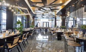 a large , modern restaurant with black and white tiled floors , multiple dining tables set for guests , and an array of seating options at Hotel Mirror Skopje