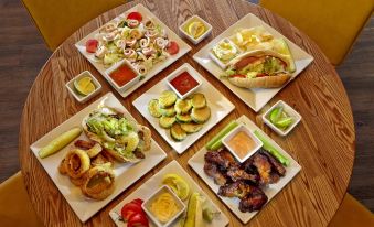 a dining table with a variety of food items , including sandwiches , salads , and other dishes at Scholar Morgantown, Tapestry Collection by Hilton