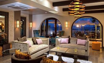 a large , well - lit living room with multiple couches and chairs arranged in various positions , creating a cozy and inviting atmosphere at Oyster Bay Beach Resort