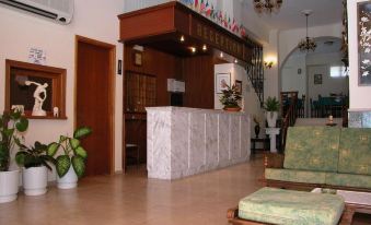 a hotel lobby with a marble reception desk , multiple chairs , and a large painting on the wall at Anamar Zante Hotel
