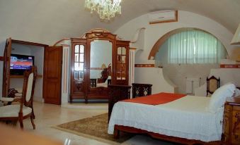 a large bedroom with a king - sized bed , a dresser , and a mirror in the bathroom at Hotel Hacienda Vista Hermosa