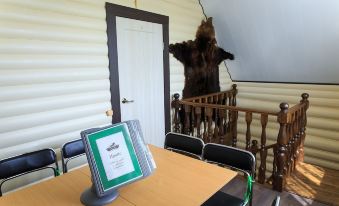 a brown bear hanging from a rope in a room , accompanied by a dining table and chairs at Allur