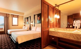 In the middle of the room, there are two beds and a sink positioned next to each other at Disney Explorers Lodge