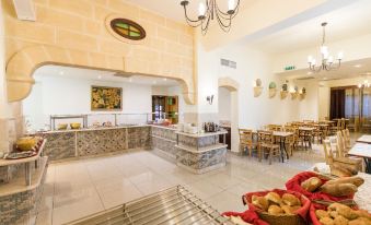 a restaurant with a long dining table , chairs , and a bread counter , along with bread on the counter at Sunflower Hotel