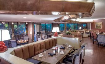 a dining area with a long table and several chairs , creating a cozy atmosphere in a restaurant at DoubleTree by Hilton Phoenix Tempe