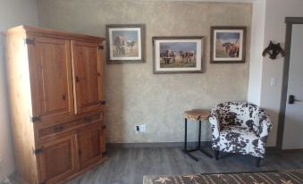 a living room with a wooden cabinet , a brown cabinet , and three framed pictures on the wall at Rays Place Inn