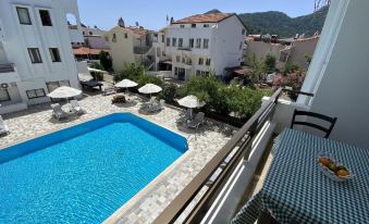 a beautiful outdoor swimming pool area with clear blue water , umbrellas , and white buildings in the background at The Diplomat Hotel