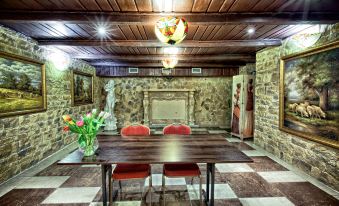 a dining room with a wooden dining table , two chairs , and a fireplace in the background at Gaja