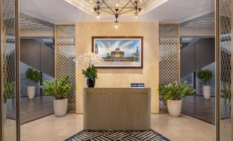a hotel lobby with a reception desk and a large painting on the wall , creating a welcoming atmosphere at Melia Vinpearl Hue