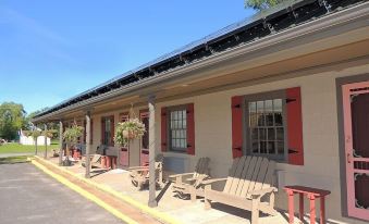 a brick building with a porch and chairs , including a rocking chair in the front at The Clipper Inn