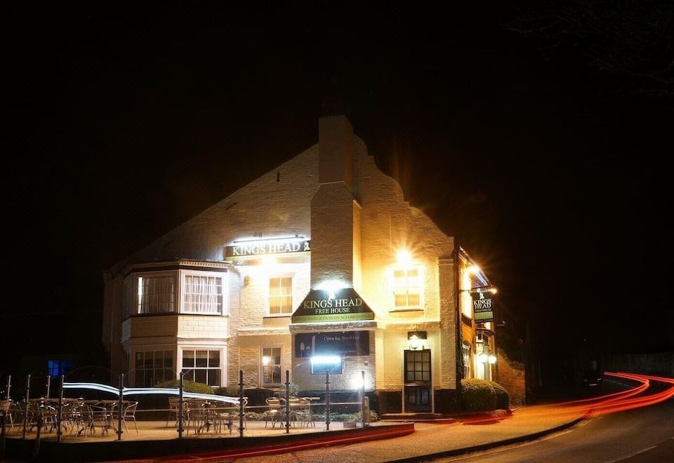 "a nighttime view of a building with a sign that reads "" the palmerston "" in front of it" at Kings Head
