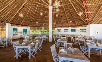 a large dining room with wooden tables and chairs arranged for a group of people to enjoy a meal together at Chale Island Resort