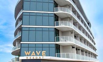 "a modern building with a curved design , named "" wave "" resort , under a clear blue sky" at Wave Resort