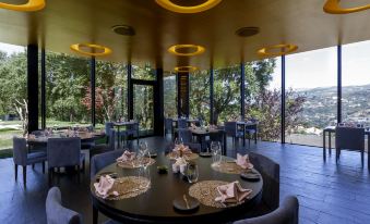 a dining room with round tables and chairs arranged for a group of people to enjoy a meal at Douro Palace Hotel Resort & Spa