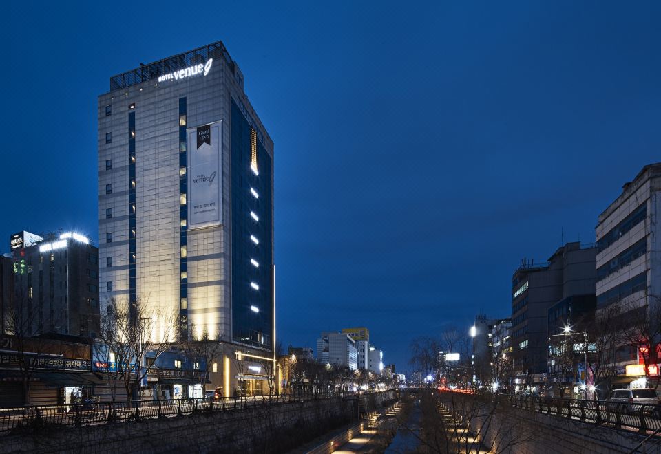 At night, there is a view of buildings in the background, with one building in the distance at Hotel Venue-G Seoul