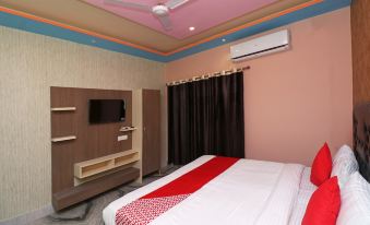 a modern hotel room with pink walls , white ceiling , and red bedspread , featuring a tv , air conditioner , and window at Collection O 27949 Hotel Kriti Green