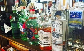 a bar with various bottles of alcohol , including whiskey and vodka , neatly arranged on the counter at The Horseshoe & Castle