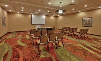 a conference room with a projector screen , chairs , and a table , all set up for a meeting or presentation at Holiday Inn Roswell