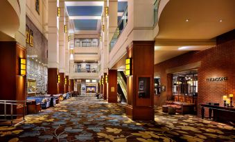 a large , well - lit hotel lobby with multiple floors and high ceilings , featuring an elegant carpet and wooden furniture at Hyatt Regency Calgary