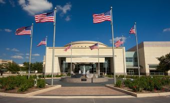 a large building with american flags flying in front of it , creating a patriotic atmosphere at The Stella Hotel, Autograph Collection