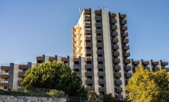 a modern apartment building with balconies and greenery , set against a clear blue sky , under a clear blue sky at Hotel Estoril Eden