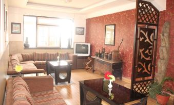 a spacious living room with a variety of furniture , including a couch , chairs , and a television at Hotel Srinagar