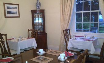 a dining room with a table set for breakfast , featuring plates , cups , and utensils on the table at Buckley Farmhouse