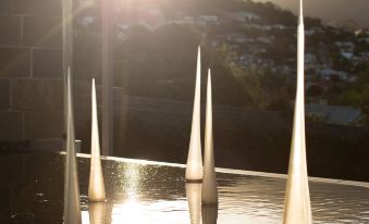 a row of white spires floating in a body of water , with the sun shining brightly in the background at Islington Hotel