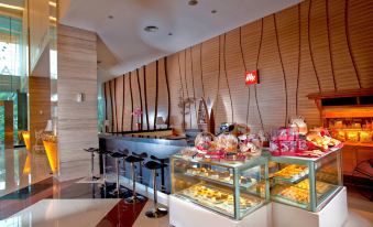 a modern restaurant with a bar area , where customers can enjoy their meals and snacks at Grand Artos Hotel & Convention