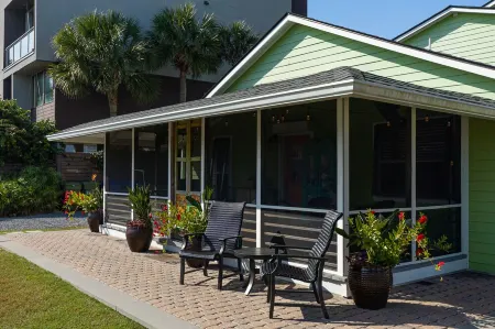 Family getaway with screened-in porch steps from surf and sun!